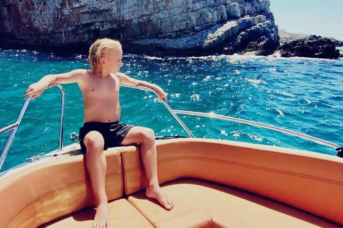 un ragazzino seduto su una barca in acqua