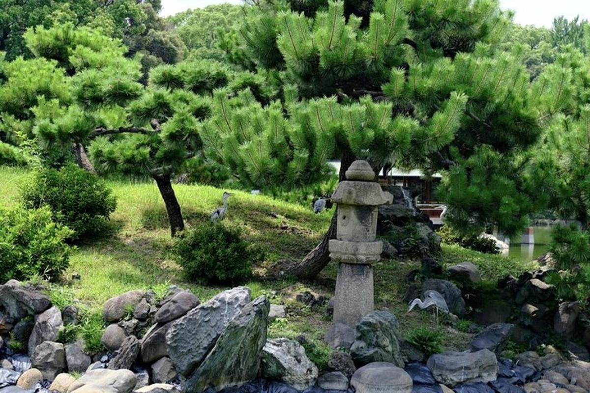 un giardino con alberi e rocce e una torre di pietra