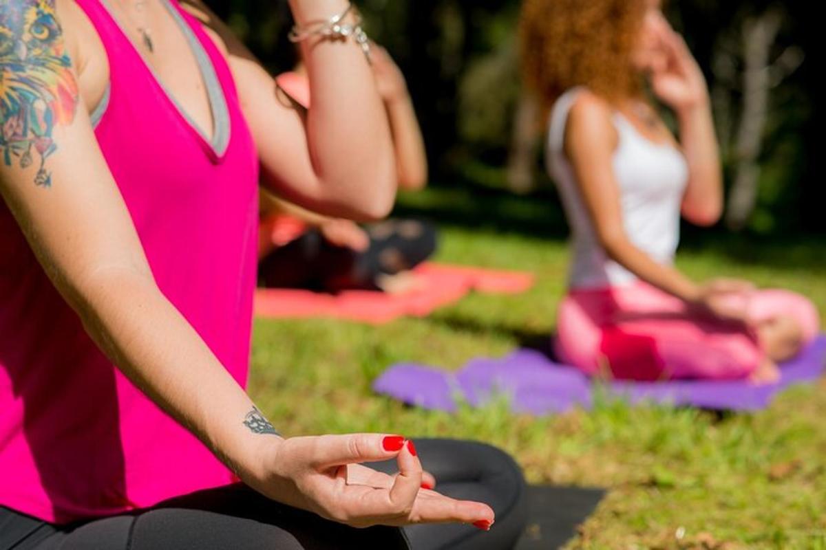 a group of women doing yoga in the grass