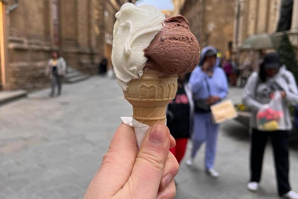 seseorang memegang coklat dan kon ais krim