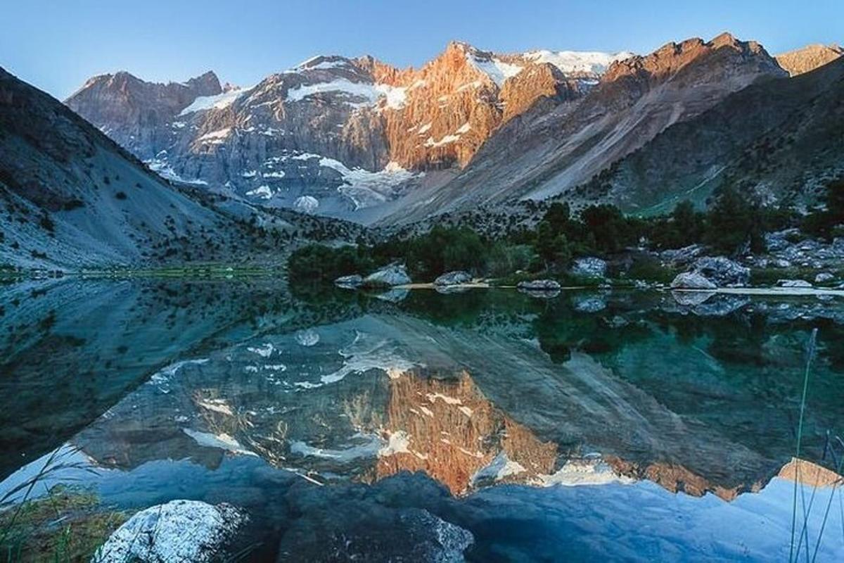 a reflection of a mountain in a body of water