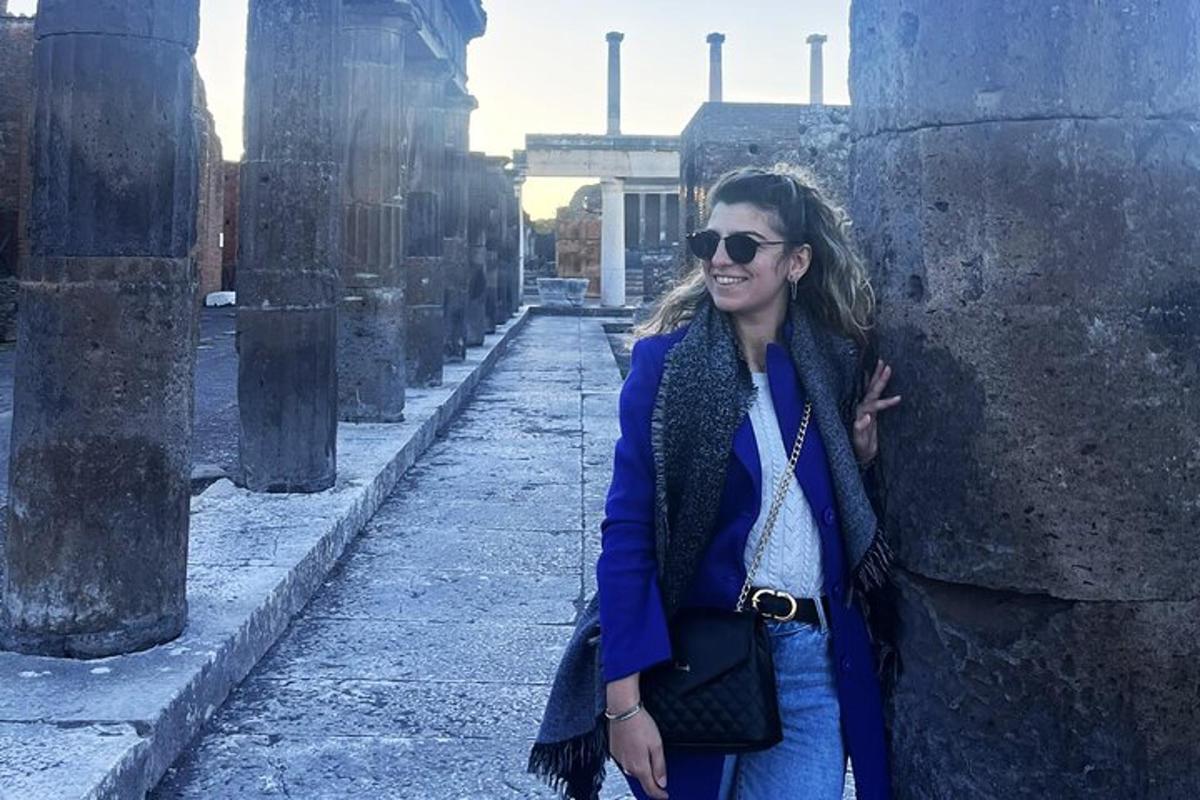 μια γυναίκα που στέκεται δίπλα σε έναν τοίχο σε ένα κτίριο