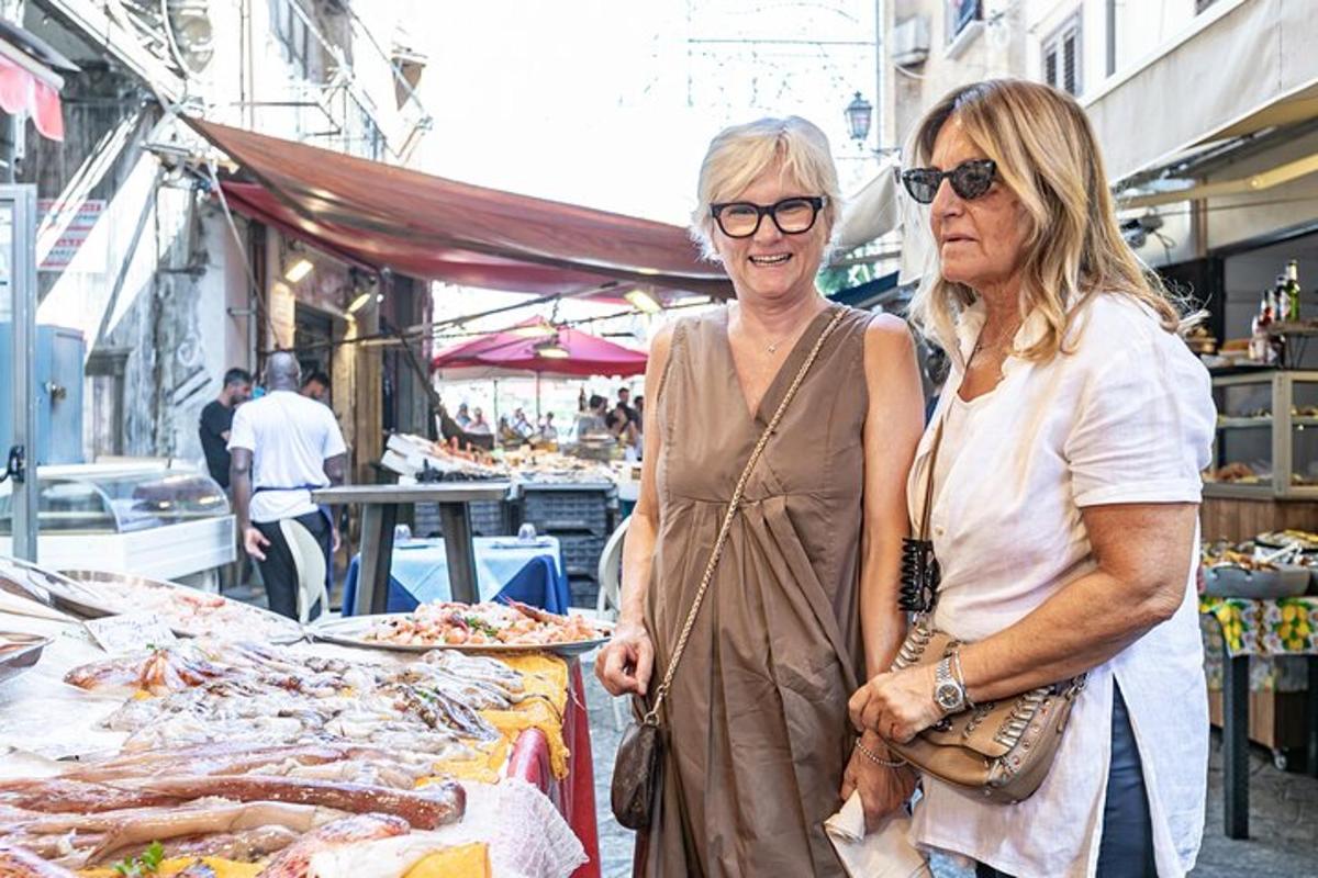 due donne in piedi davanti a un mercato con la carne