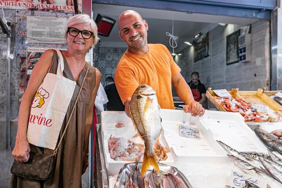 Un hombre y una mujer de pie detrás de un mostrador con un pescado.