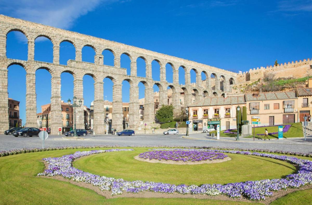 un gran edifici de pedra amb un jardí circular al davant
