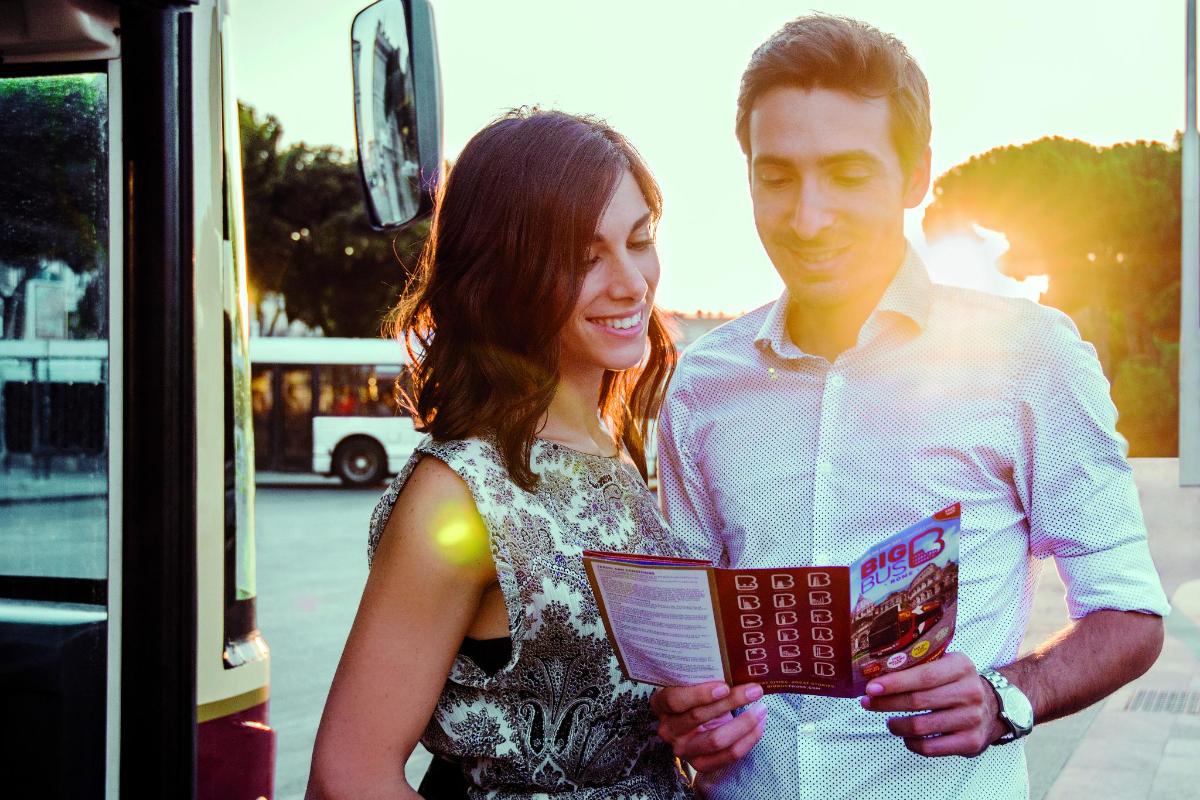 a man and a woman standing next to a bus