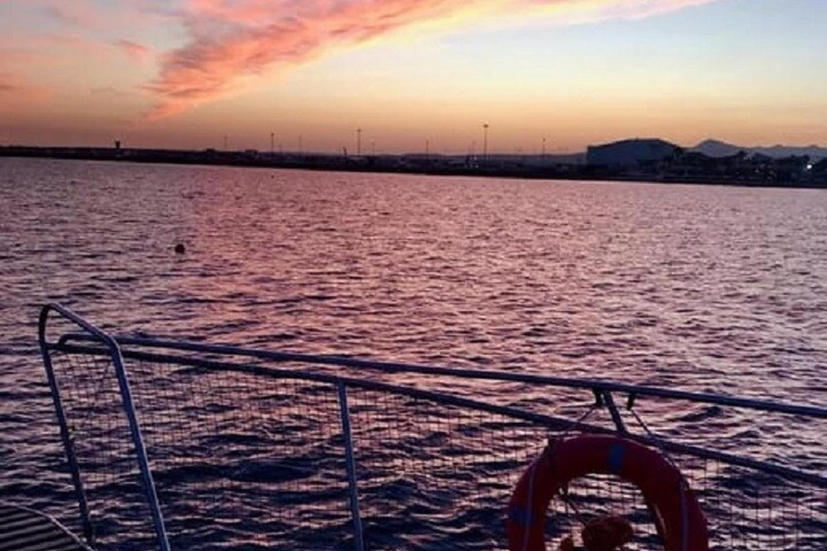 a boat in a body of water with a sunset