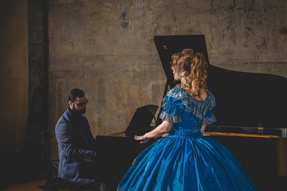 una donna in abito blu in piedi accanto a un pianoforte