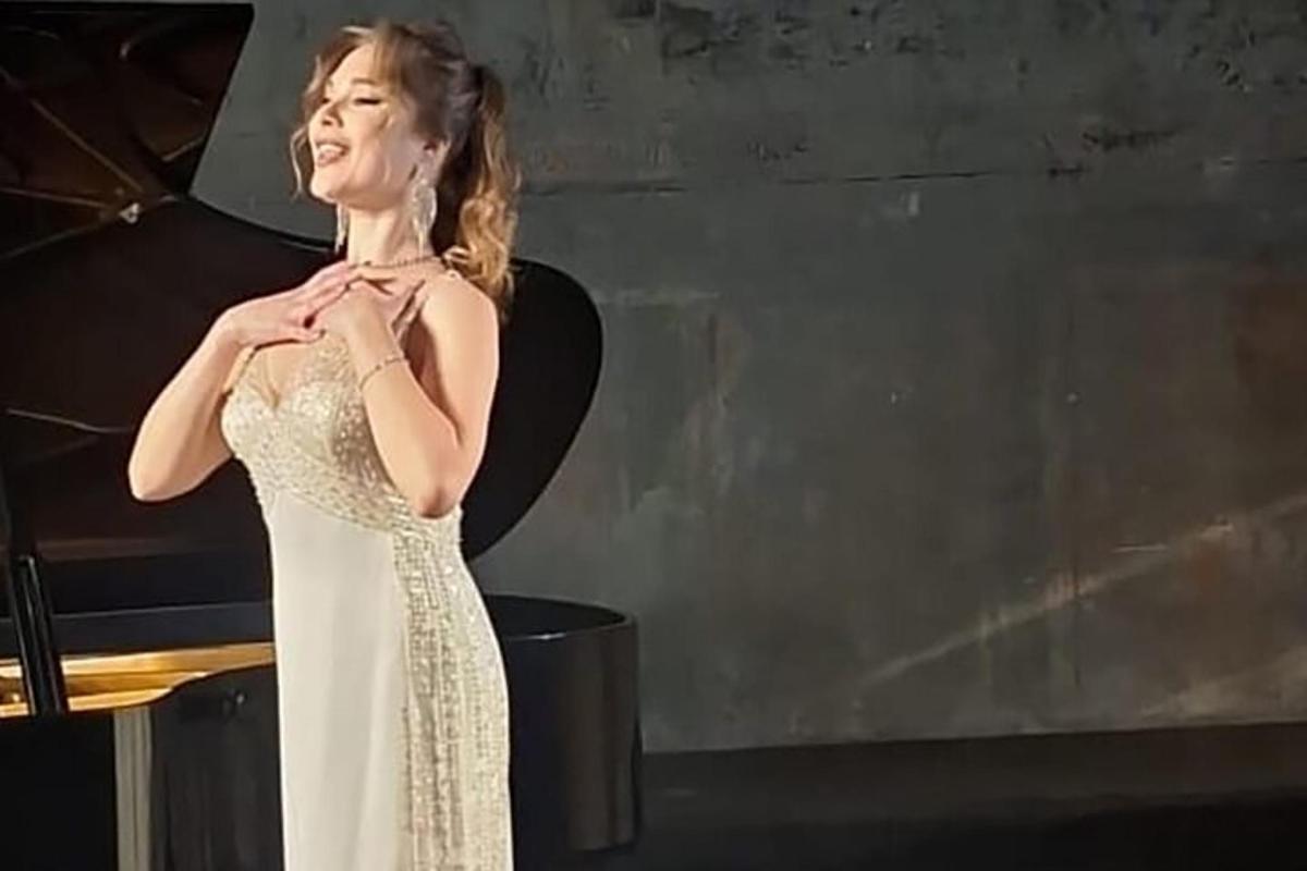 una dona amb un vestit blanc que sosté un paraigua