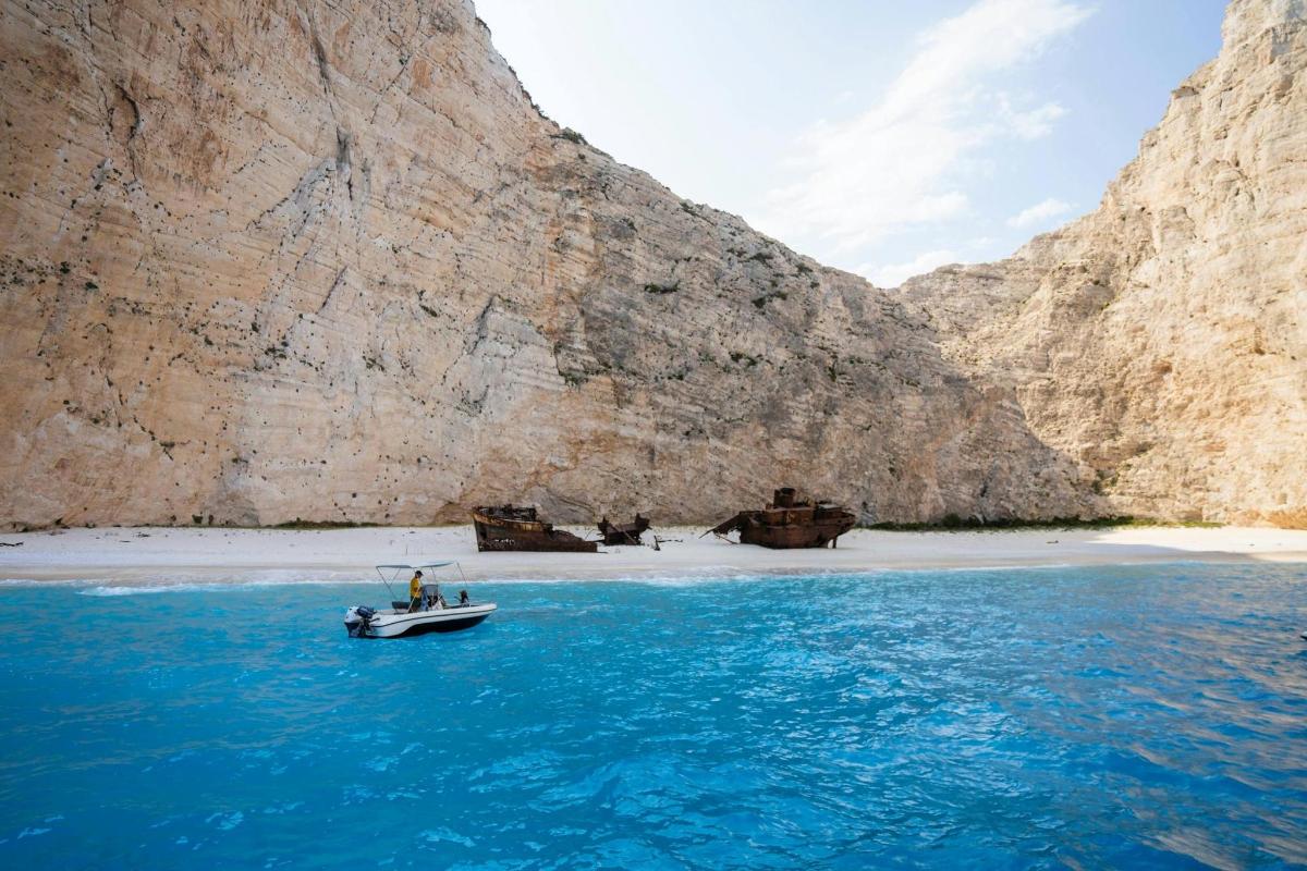 una barca in acqua accanto a una montagna