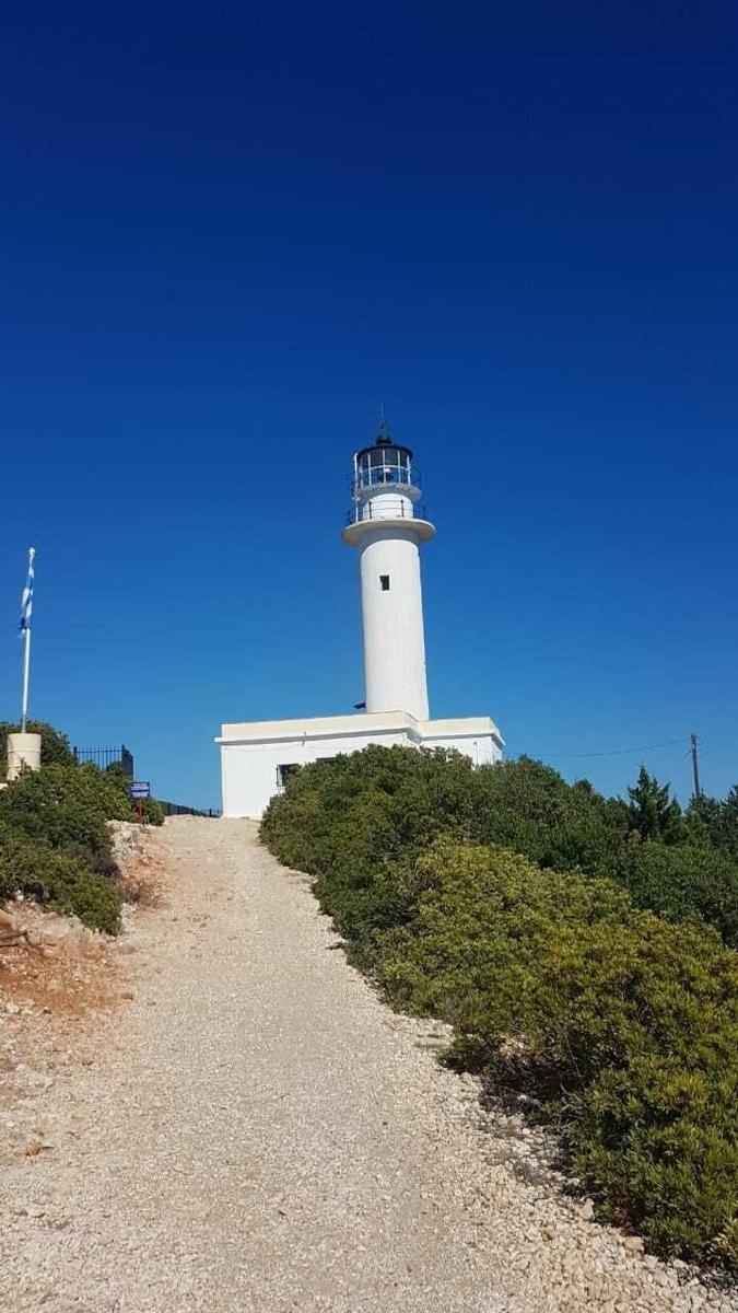 a lighthouse on top of a hill with a gravel road