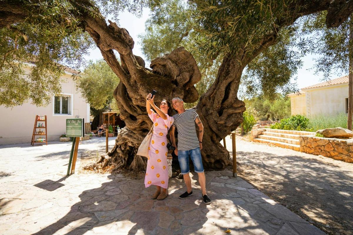 a man and a woman standing next to a tree