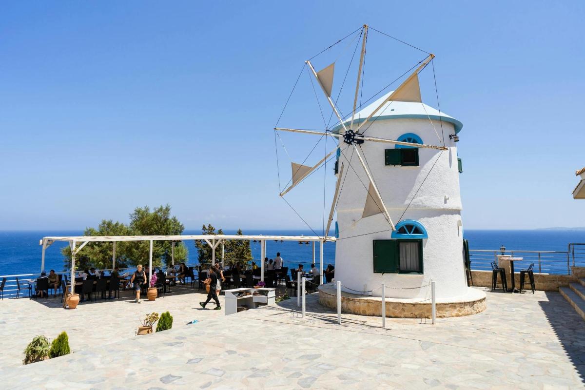 ένας ανεμόμυλος που κάθεται πάνω σε μια παραλία