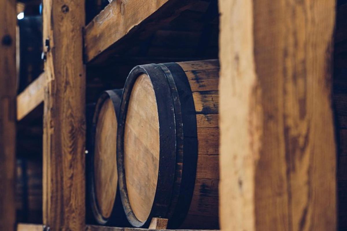 Una fila de barriles de vino en un estante de madera