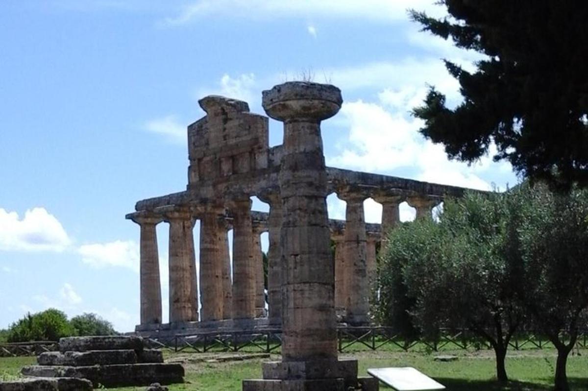 un edifici antic amb un pilar en un camp