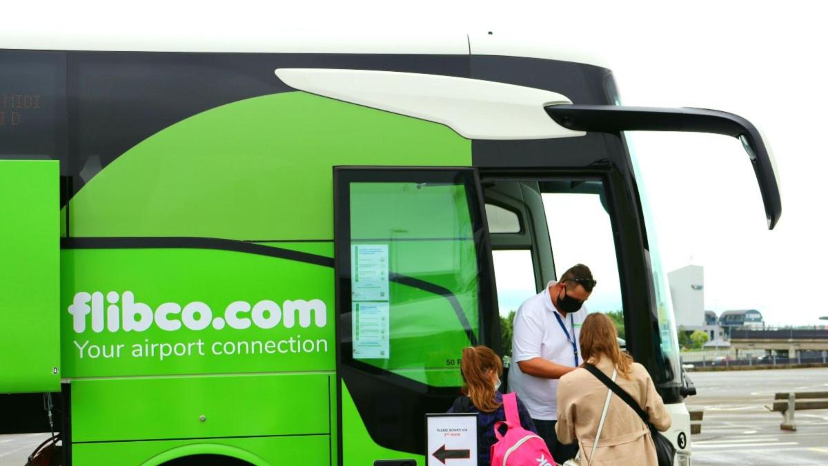 Un grupo de personas subiendo a un autobús verde.