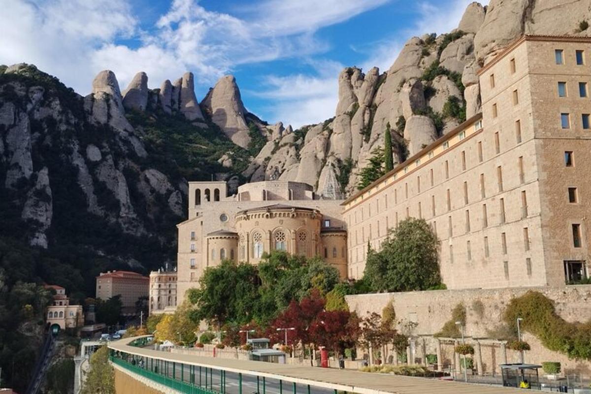 un edifici davant d'una muntanya al costat d'una carretera
