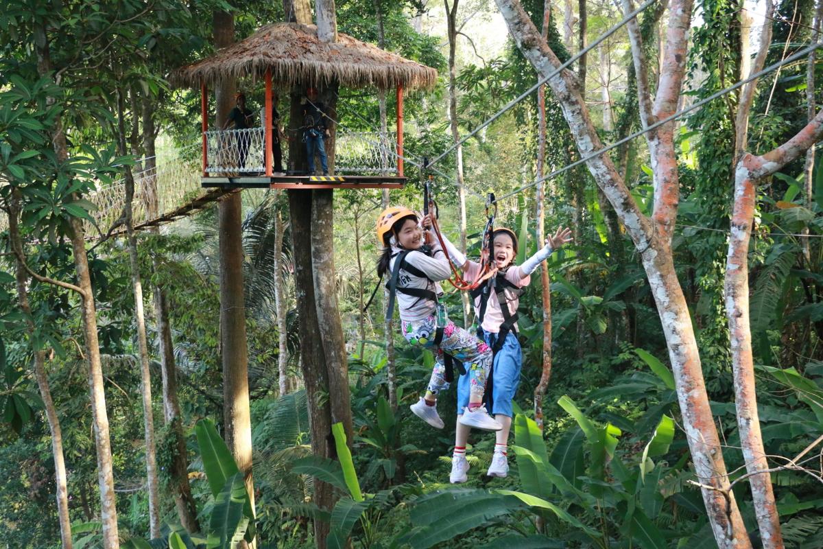 dvě dívky se houpou na zip line v džungli