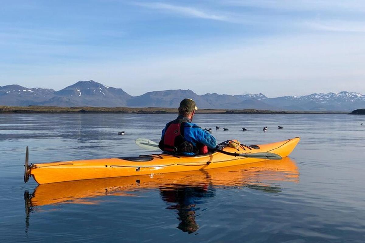 a man sitting in a yellow kayak on the water