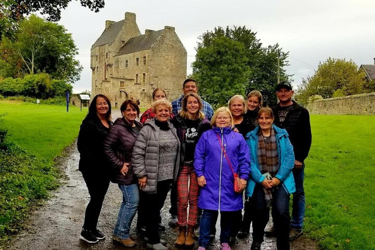 eine Gruppe von Menschen posiert vor einem Schloss