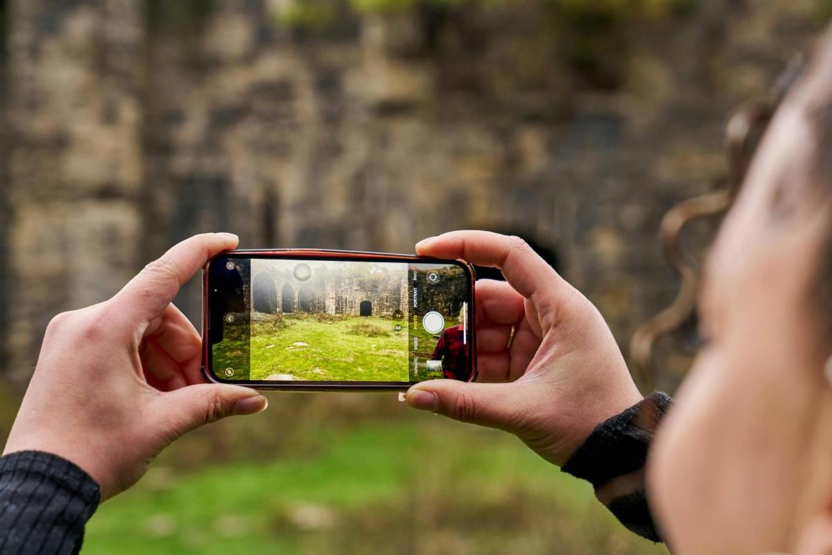 cilvēks fotografē ar mobilo tālruni