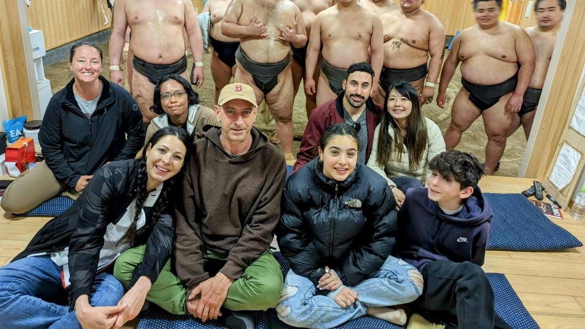 група людей, що сидять на підлозі та позують для фотографії