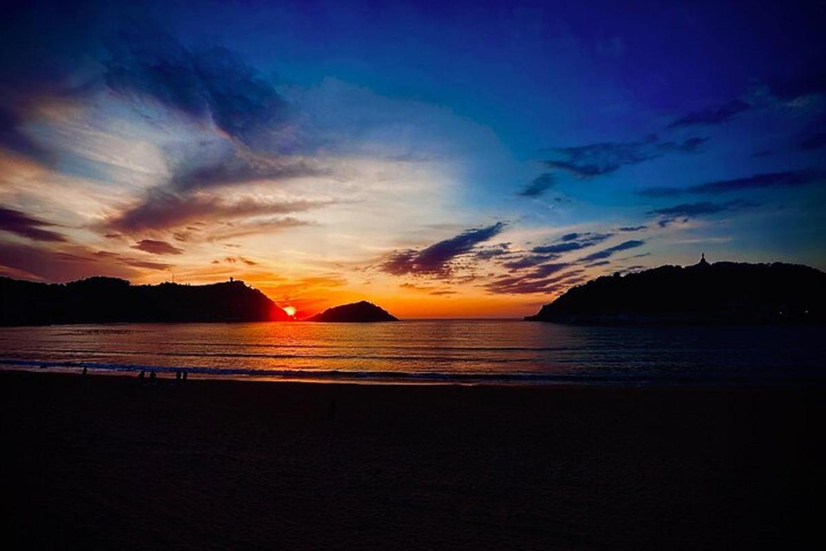 a sunset on a beach with the ocean and the sky