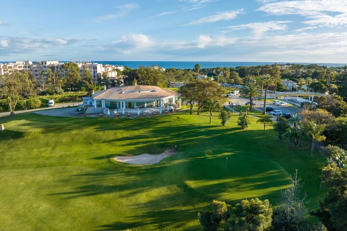 an overhead view of a golf course with a green