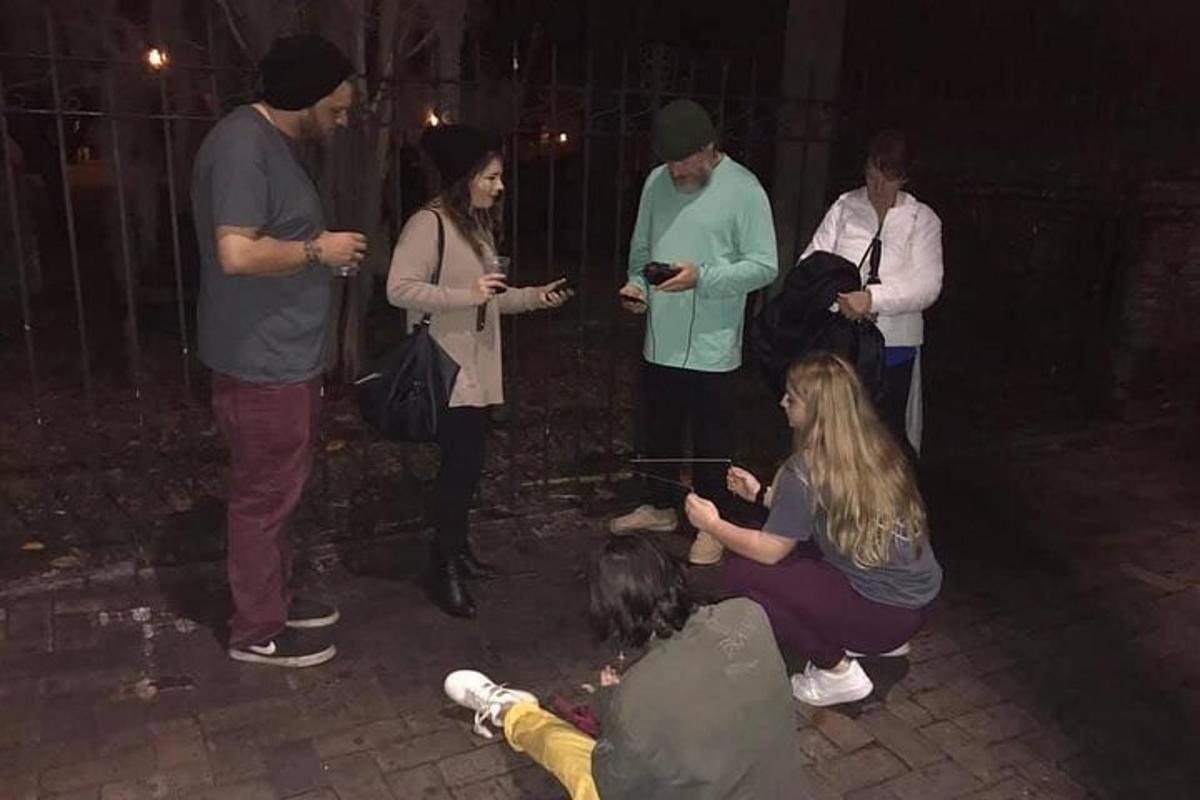 a group of people standing around looking at their cell phones
