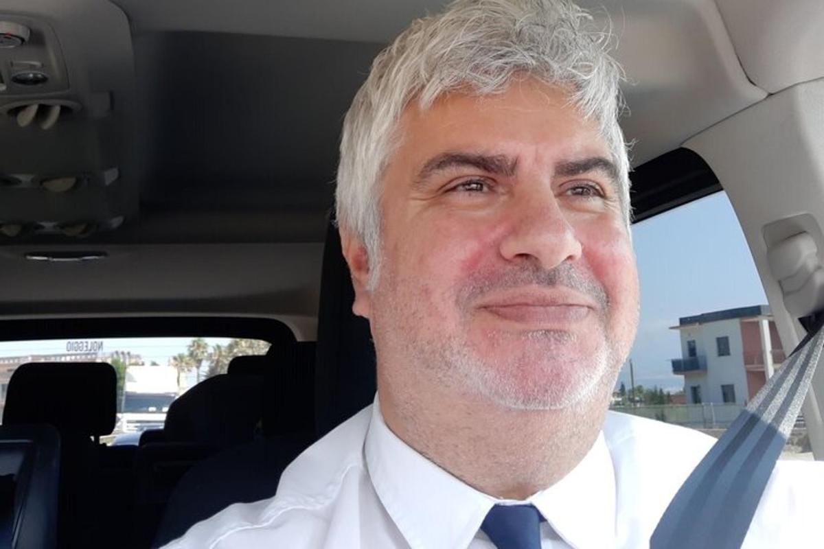 Un hombre con corbata sentado en un coche.