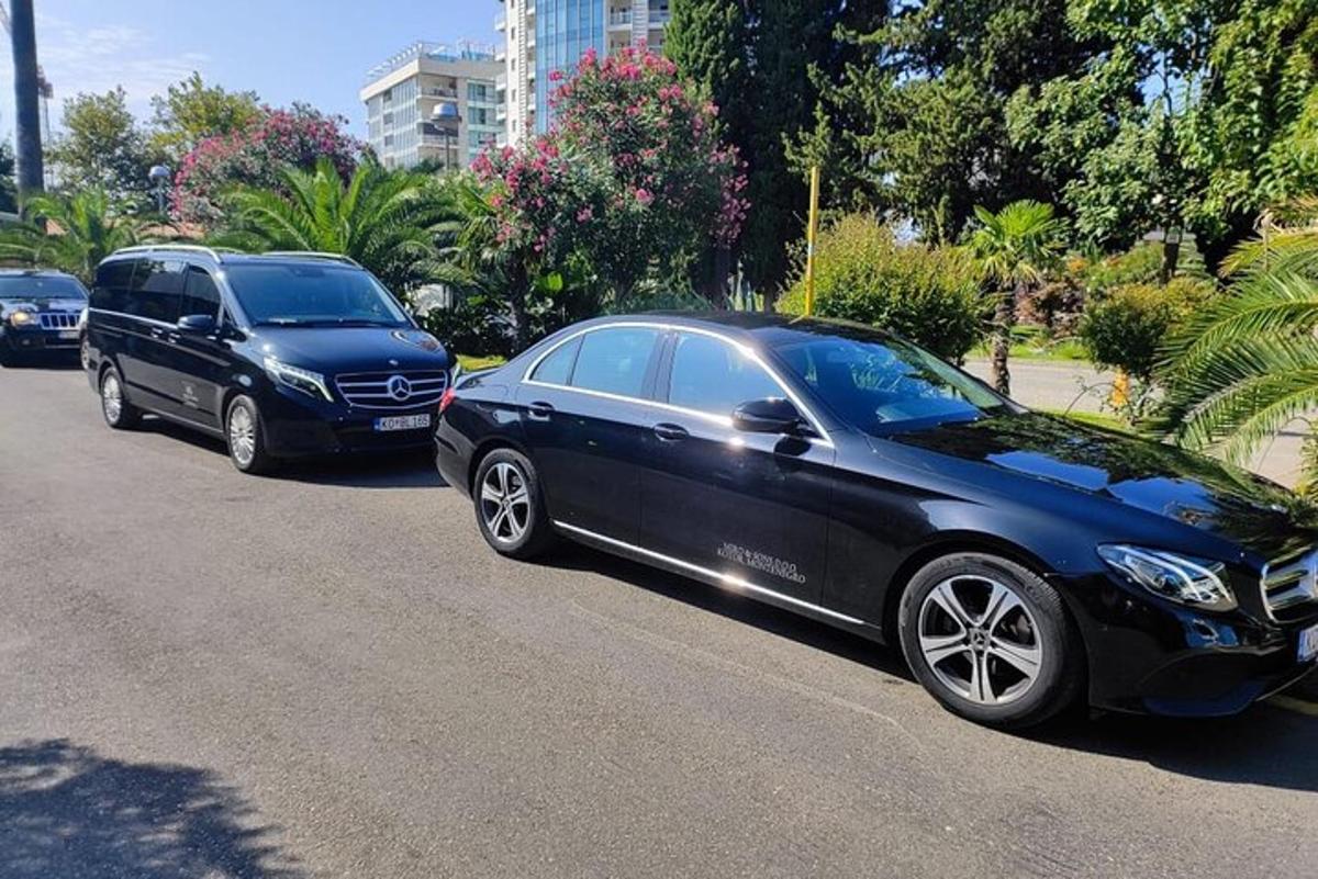 černé auto a dodávka zaparkované na ulici