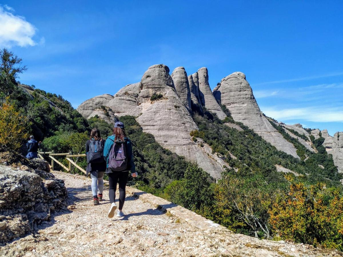 two people walking on a trail in the mountains
