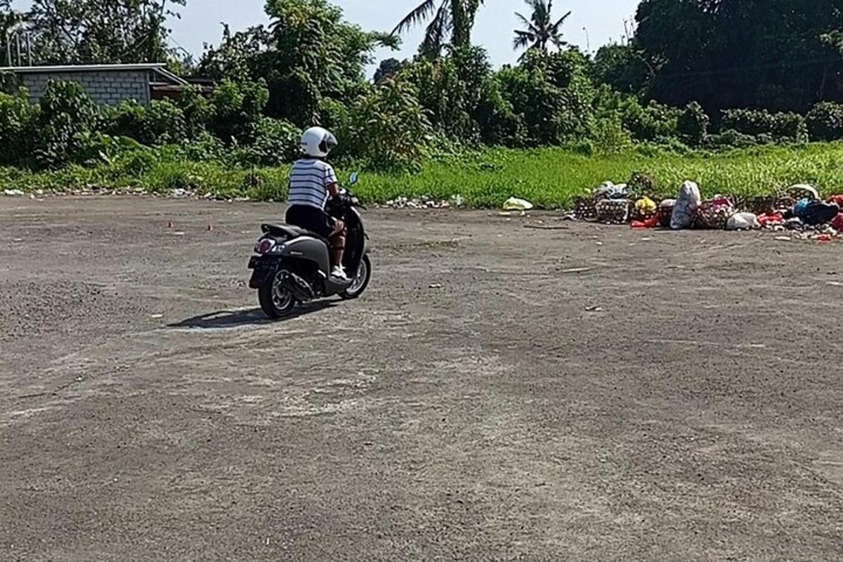 un bambino che guida una motocicletta in un parcheggio