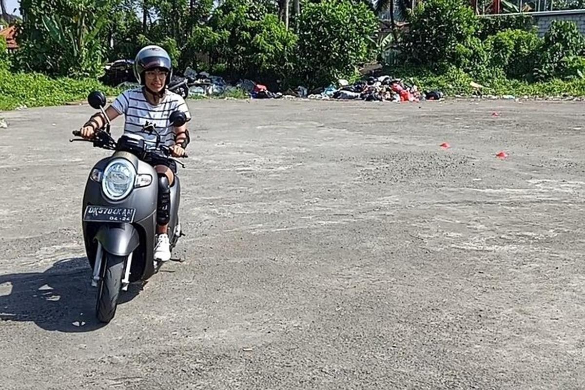 un ragazzo in sella a una motocicletta per strada