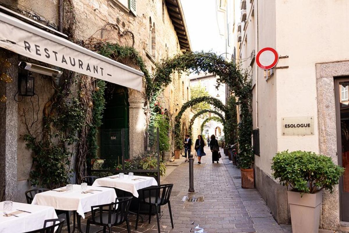eine Straße mit Tischen und Stühlen in einer Gasse