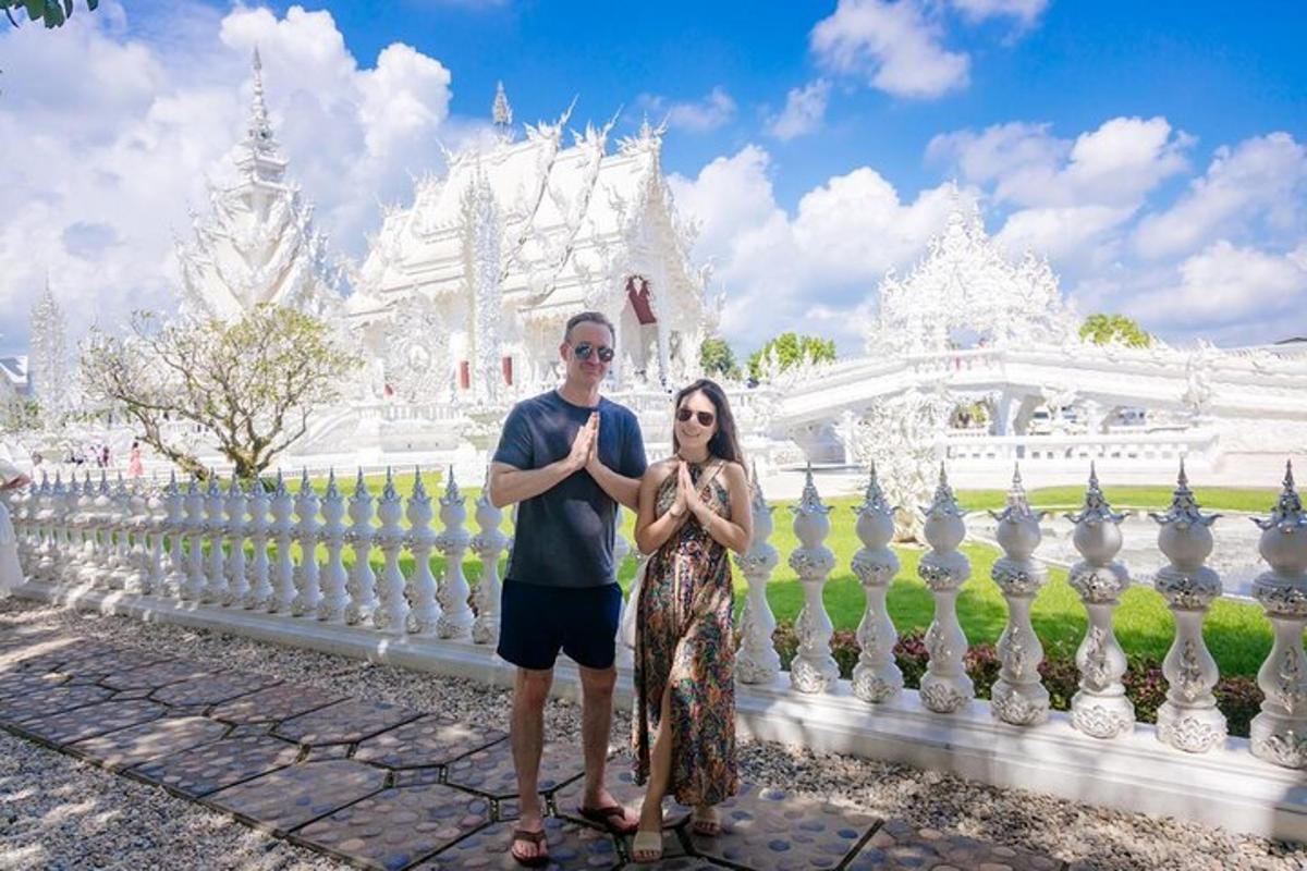 một người đàn ông và một người phụ nữ đứng trước một tòa nhà màu trắng