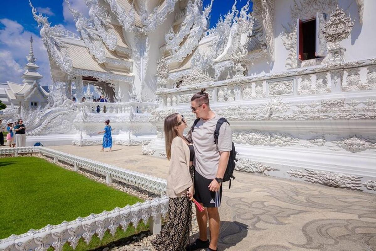 một người đàn ông và một người phụ nữ đứng trước một tòa nhà màu trắng