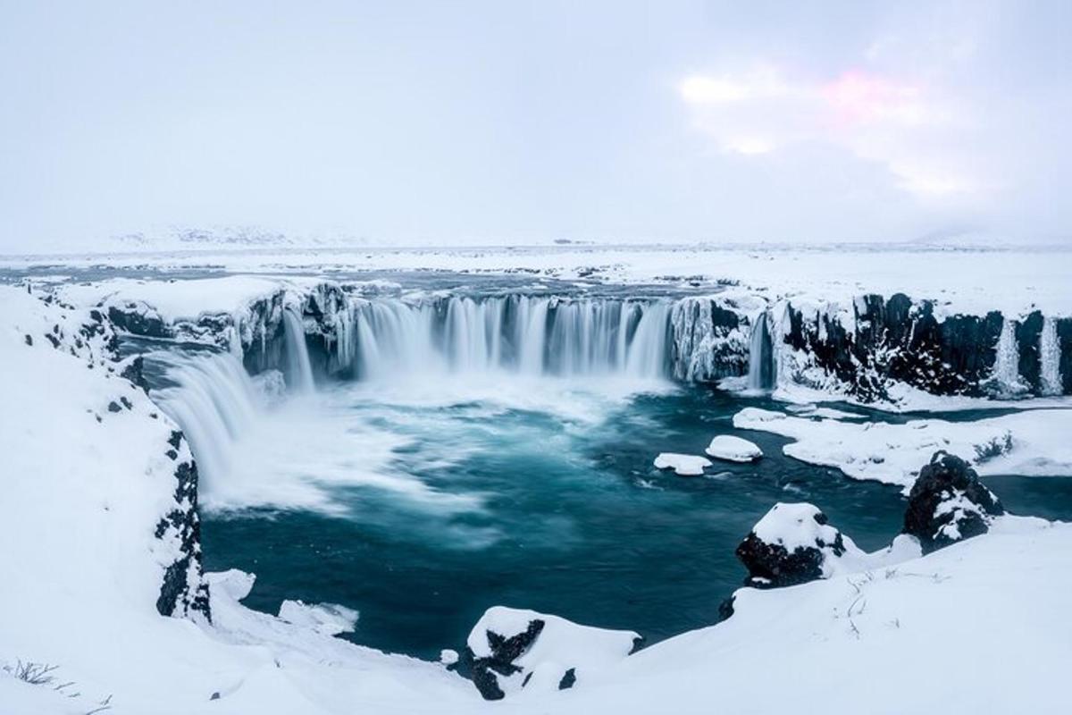 una cascada congelada amb neu a terra