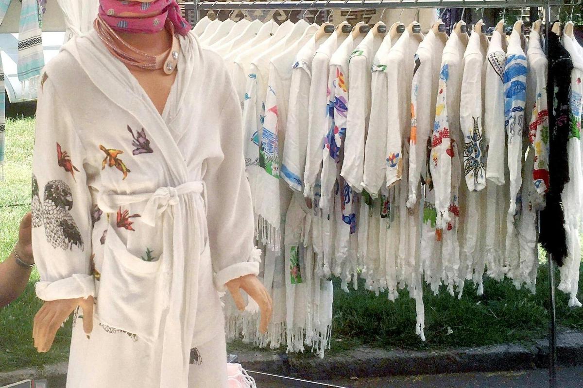 a woman standing in front of a rack of clothes