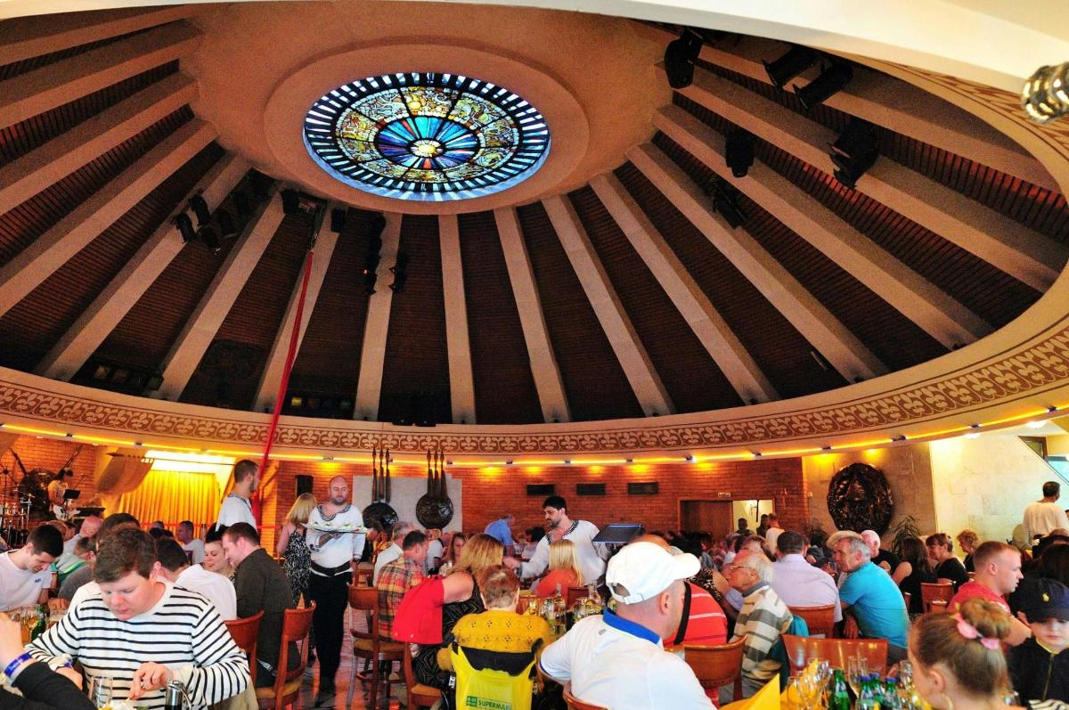 a crowd of people in a restaurant with a stained glass window