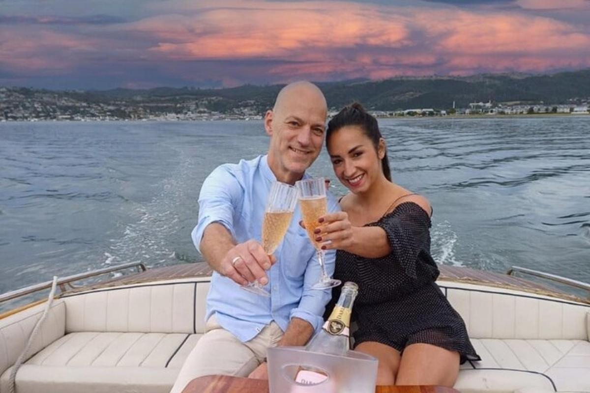 a man and woman sitting on a boat with drinks