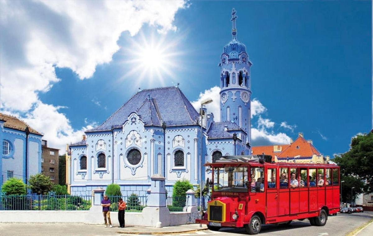 Un tranvía rojo frente a una iglesia