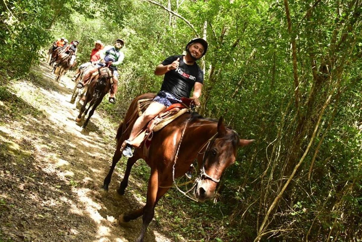 a group of people riding horses on a trail