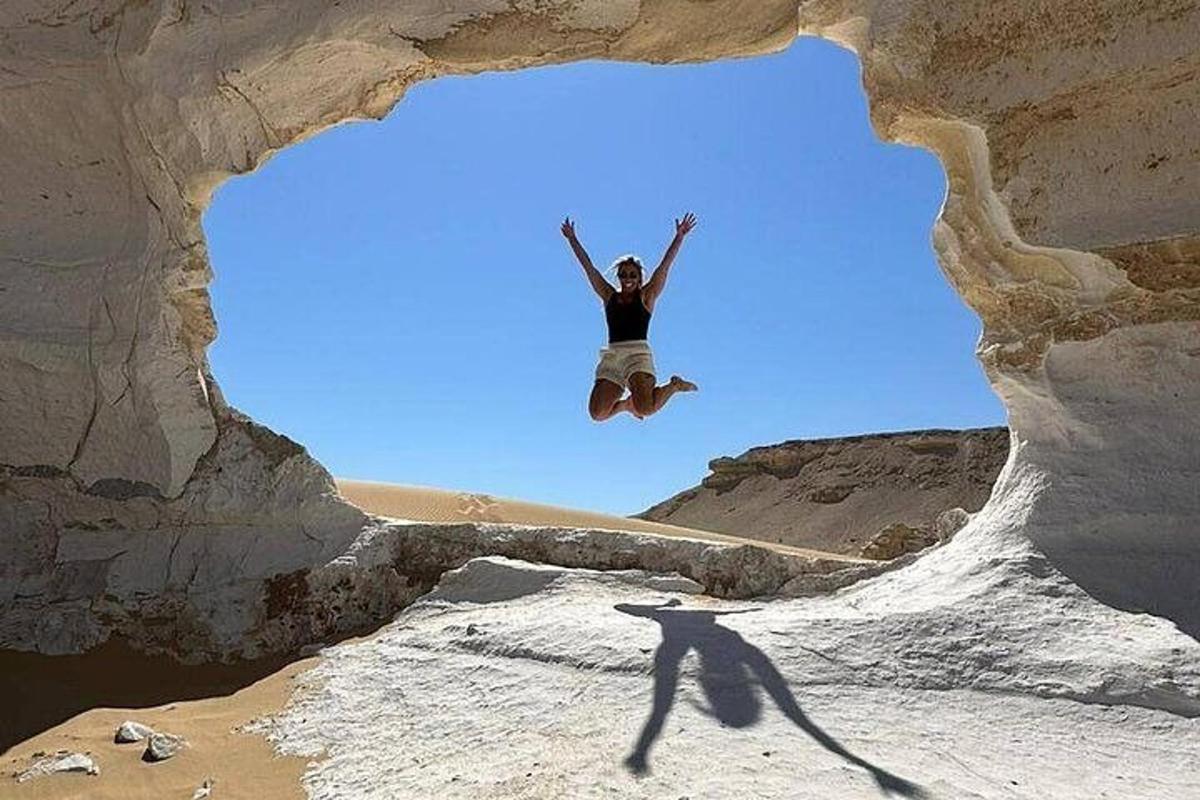 una persona che salta in aria in una formazione rocciosa