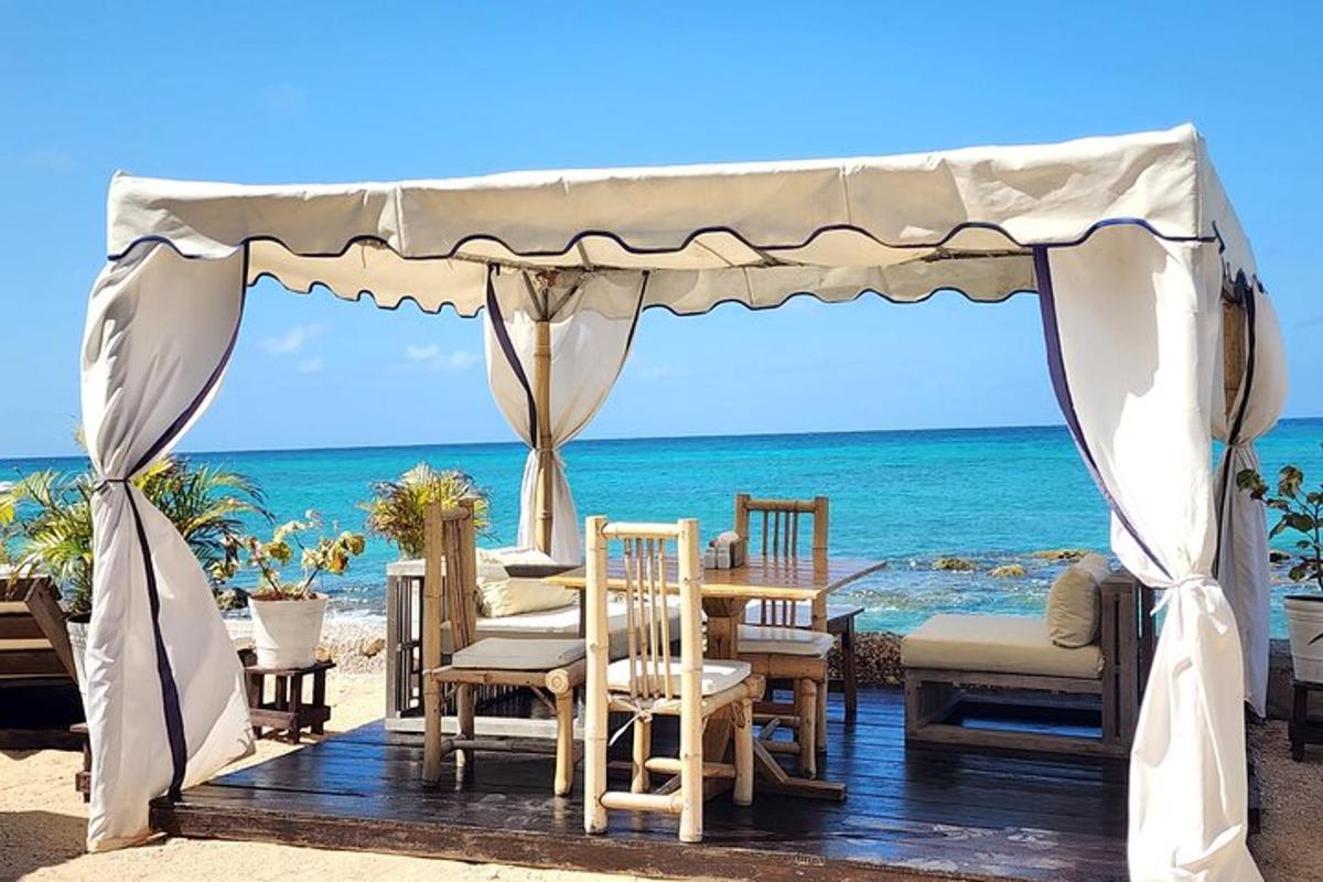 a gazebo on the beach with chairs and tables