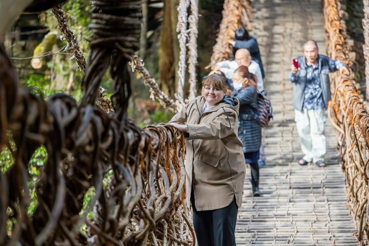 a woman is standing on a rope bridge