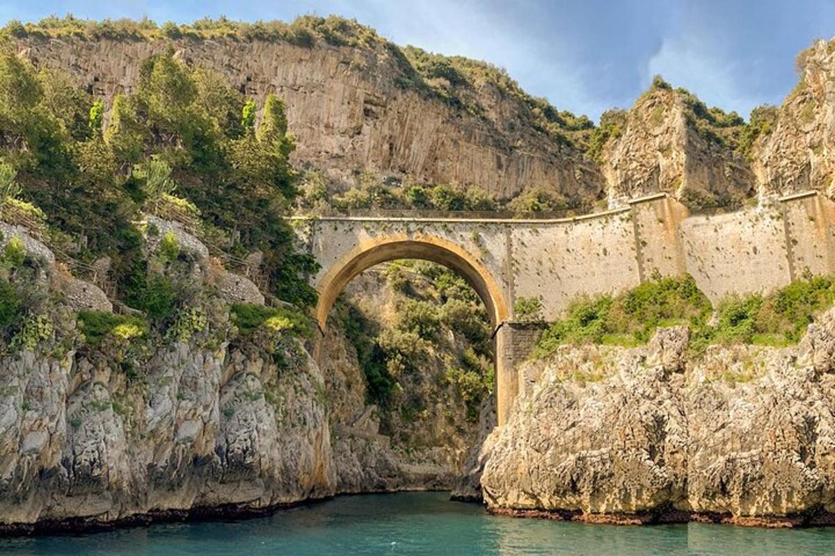 un puente sobre el agua al lado de una montaña