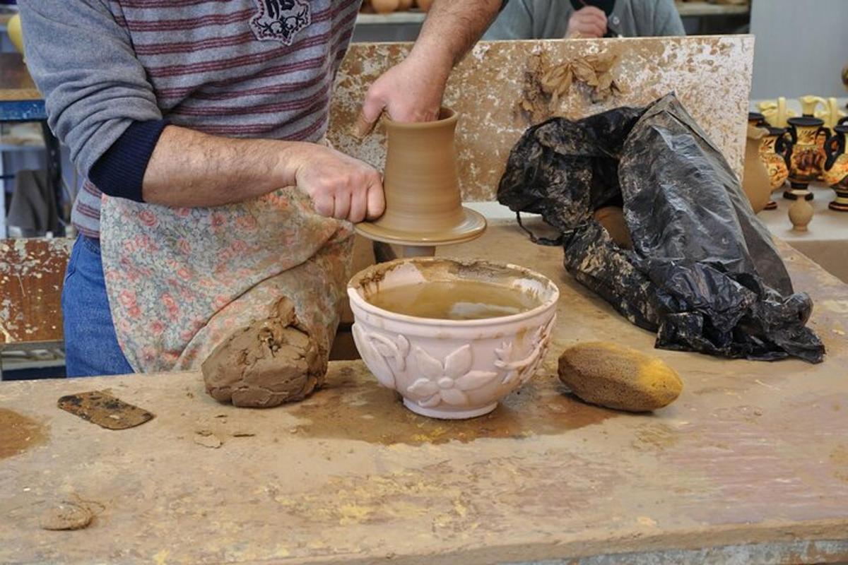 ein Mann, der eine Vase auf einem Tisch herstellt