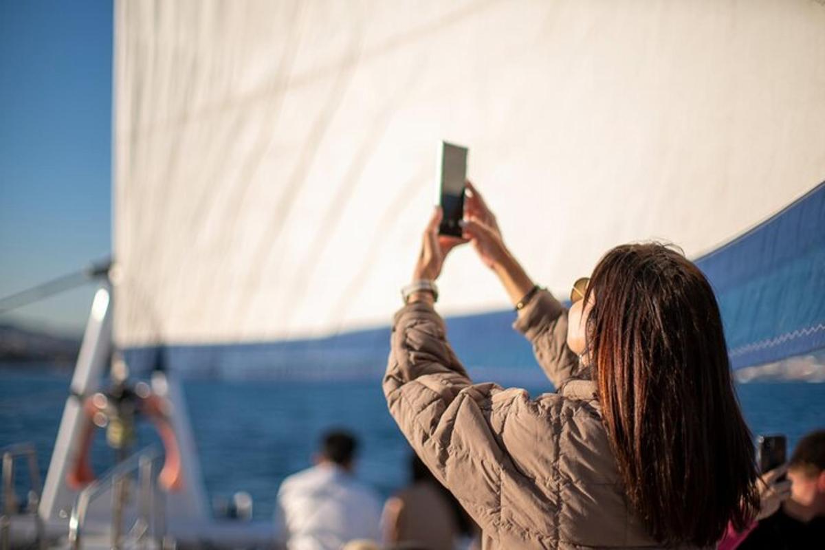 een vrouw die met haar mobiele telefoon een foto van een boot maakt
