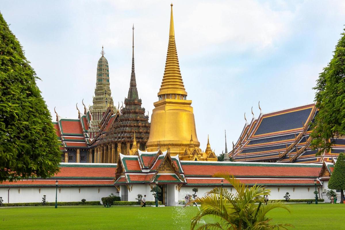 ein Tempel in Bangkok mit einer grünen Wiese davor